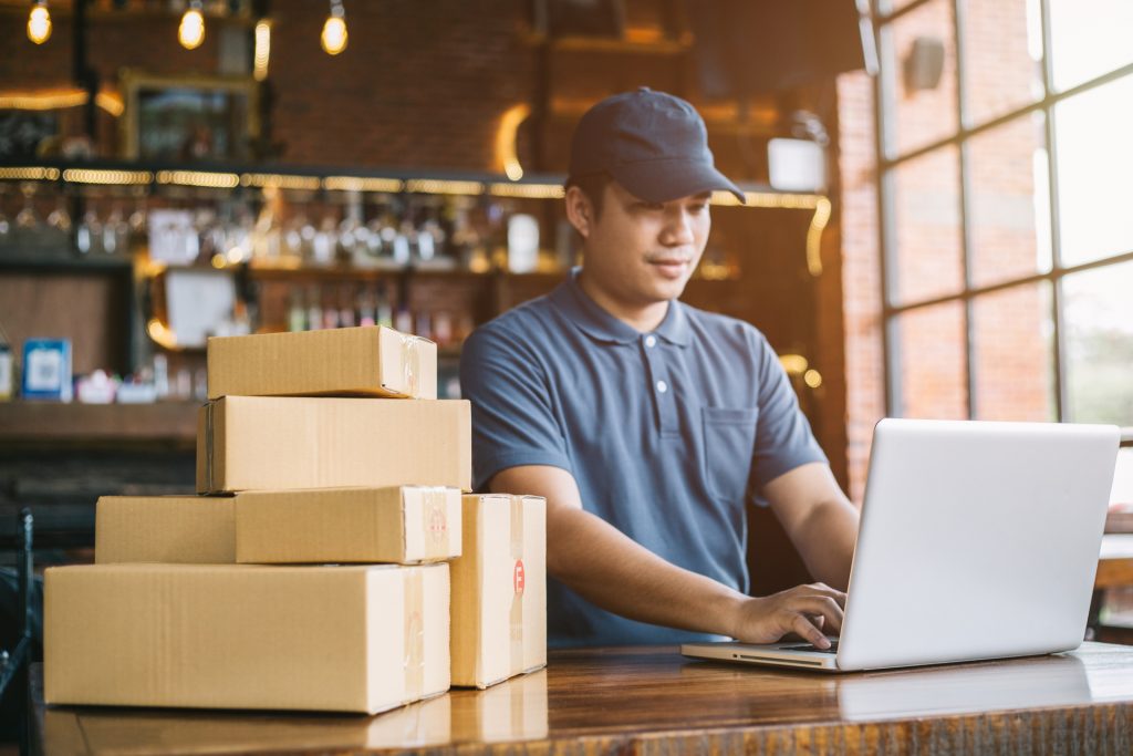 Small business man on laptop in shop